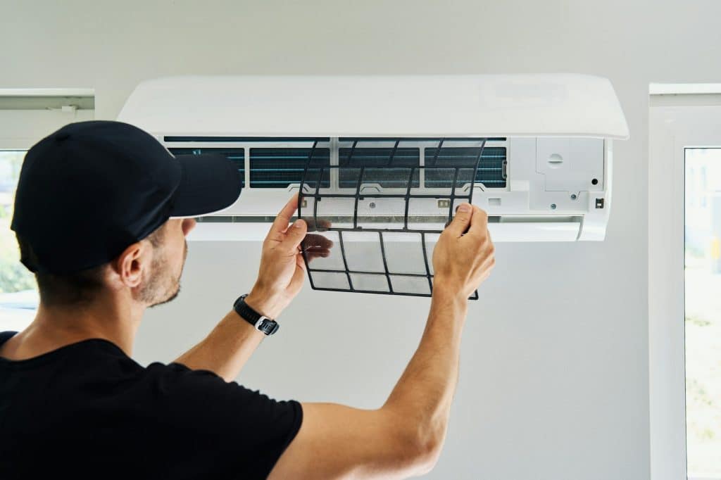 Air conditioner maintenance. Male technician repairing cooling system