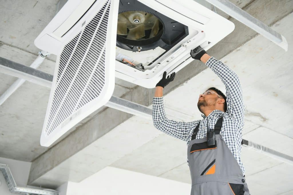 specialist cleans and repairs the wall air conditioner